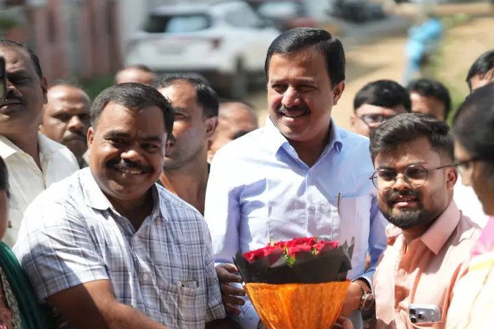 ಕಚೇರಿಯ ಹೊರಗೆ ಅತಿಥಿಯನ್ನು ಹೂಗುಚ್ಛದೊಂದಿಗೆ ಸ್ವಾಗತಿಸಲಾಗುತ್ತಿದೆ.