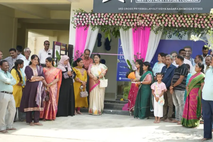 ಹೂವಿನಿಂದ ಅಲಂಕರಿಸಿದ ಕಚೇರಿ ಪ್ರವೇಶದಲ್ಲಿ ಅತಿಥಿಗಳು.