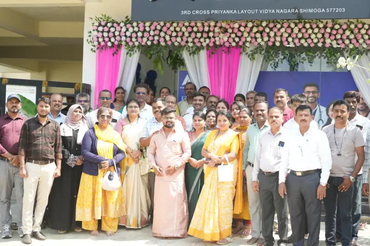 ಹೂವಿನಿಂದ ಅಲಂಕರಿಸಿದ ಕಚೇರಿ ಪ್ರವೇಶದ ಮುಂದೆ ಅತಿಥಿಗಳು, ಶಿಕ್ಷಕರು ಮತ್ತು Apex ತಂಡ.