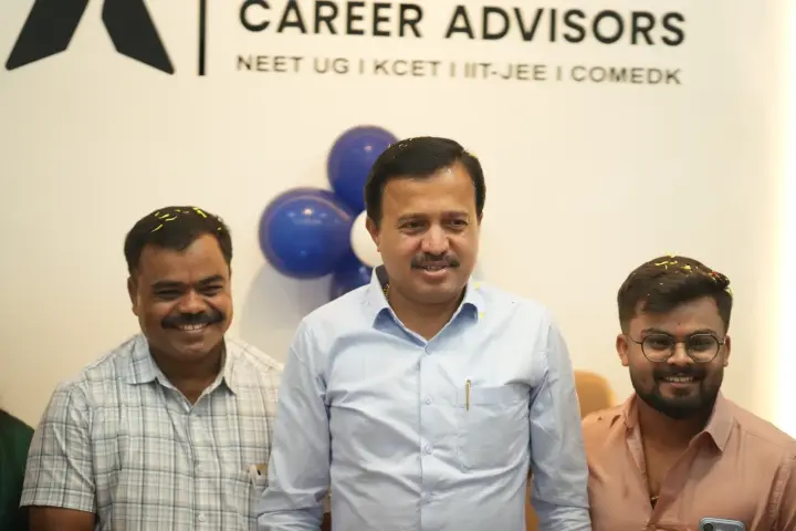 ಕಚೇರಿಯ ಒಳಗೆ Apex Career Advisors ಫಲಕದ ಮುಂದೆ ನಗುತ್ತಿರುವ ಮೂವರು ಅತಿಥಿಗಳು.